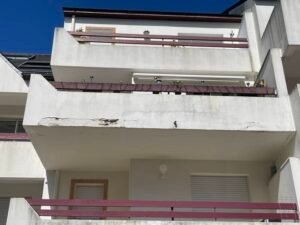 Risques et conséquences de fissures visibles sur balcon béton de façade à LA BAULLE 44500.